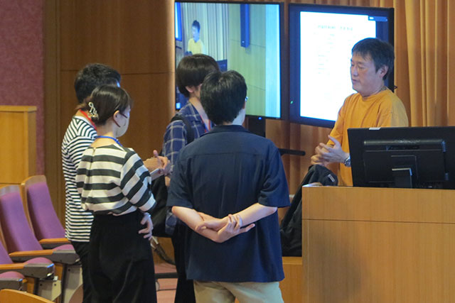 student participants talk to a lecturer