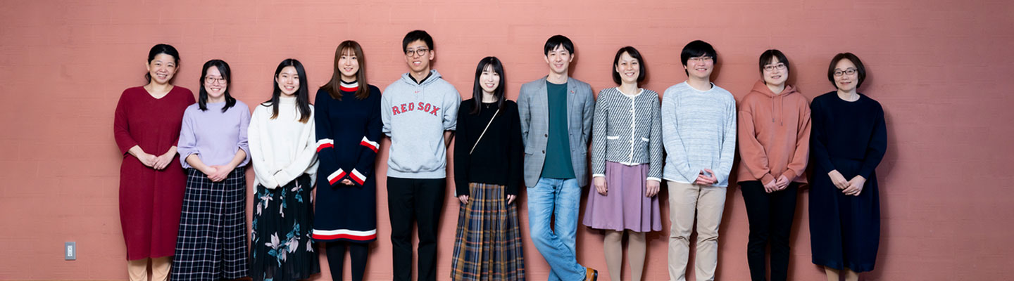 lab members standing in front of a brick wall